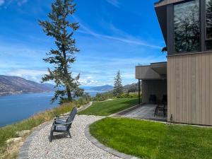 a bench sitting on the side of a house overlooking the water at Kelowfornia Lakeview Retreat in Kelowna