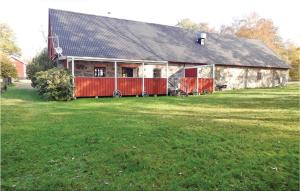 a large barn with a large grass field in front of it at 2 Bedroom Nice Home In Urshult in Urshult
