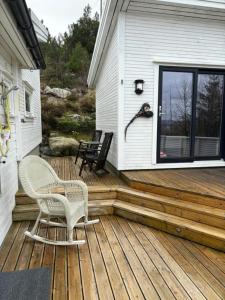 a wooden deck with two chairs on a house at Hytte på Bersagel in Sandnes