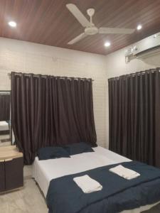 a bedroom with a large bed with black curtains at White smoke villa in Igatpuri