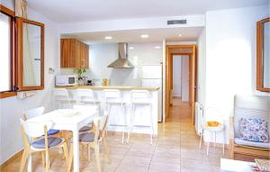 a kitchen with a white table and white chairs at Cozy Apartment In Tossa De Mar, Girona in Tossa de Mar +6 photos