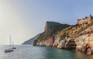 a boat in the water next to a cliff at Casa Manuela in Marinella di Sarzana