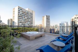 a patio with blue chairs and a bench on a balcony at My One Bela Vista - Studios por temporada in Sao Paulo