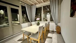 a dining room with a white table and chairs at Apostolis House in Mikonos