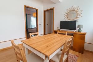 comedor con mesa de madera y TV en Bio Vida, en São Vicente Ferreira