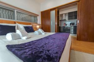 Un dormitorio con una cama grande con sábanas y almohadas moradas. en Bio Vida, en São Vicente Ferreira