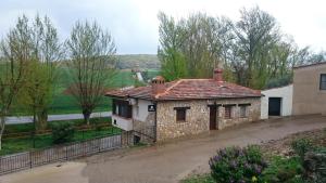 an old stone house with a red roof at Apartamentos Fuentevieja in Arbancón