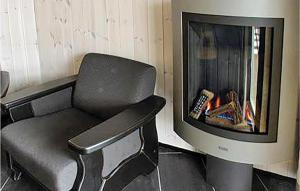 ヘムセダールにあるGorgeous Apartment In Hemsedalのテレビのある暖炉の前の椅子 +3枚の写真