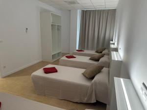 A bed or beds in a room at Albergue O Pedrón Hostel & Rooms