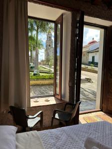 a bedroom with a bed and two chairs and a window at Casa Hotel Serena in Guadalupe +20 photos