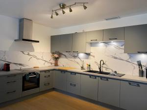 a kitchen with white cabinets and marble counter tops at Gite pour 8 p avec Piscine sur domaine 3Ha in Béziers