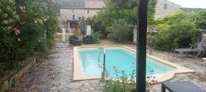 ein Swimmingpool in einem Hof mit einem Haus in der Unterkunft La Dame Blanche in Saint-Maurice-dʼIbie