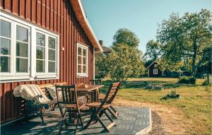a patio with a table and chairs next to a building at Cozy Home In Södra Vi With Sauna in Södra Vi