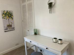 a white desk with two cups on it in a room at Henley Town Rooms in Henley on Thames