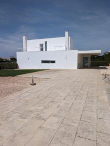 una casa blanca con una gran entrada delante de ella en White Beach Villa, en Sagres 9 fotos más
