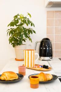 two plates of croissants on a kitchen counter with a plant at Le Cocon d'Alice - Cosy, calme, central et climatisé in Annecy