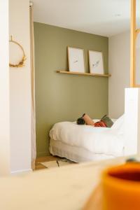 a person laying on a bed in a room at Le Cocon d'Alice - Cosy, calme, central et climatisé in Annecy