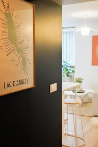 a map of la damage hanging on a wall in a living room at Le Cocon d'Alice - Cosy, calme, central et climatisé in Annecy