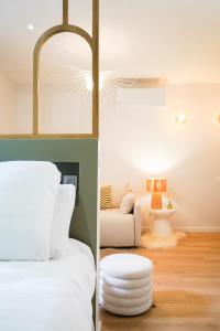 a bedroom with a white bed and a white chair at Le Cocon d'Alice - Cosy, calme, central et climatisé in Annecy