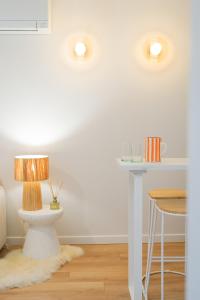 a room with a table and a lamp on a stool at Le Cocon d'Alice - Cosy, calme, central et climatisé in Annecy