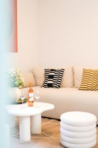 a living room with a couch and a table with wine glasses at Le Cocon d'Alice - Cosy, calme, central et climatisé in Annecy