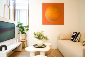 a living room with a couch and a tv at Le Cocon d'Alice - Cosy, calme, central et climatisé in Annecy