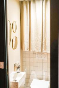 a bathroom with a toilet and a sink and a window at Le Cocon d'Alice - Cosy, calme, central et climatisé in Annecy