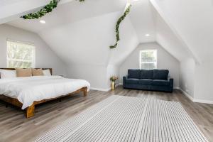 a bedroom with a bed and a blue couch at Victory Villa - 5 BR Home 5 Min From Campus in South Bend +28 photos