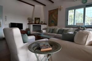 a living room with white couches and a table at La Raganetta in Cartabubbo