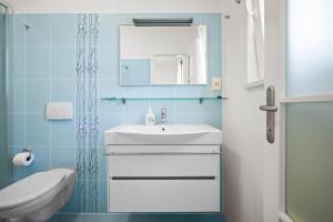 a bathroom with a sink and a toilet and a mirror at House , Seafront Apartment Pelegrin in Stomorska +32 photos