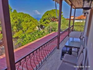 a balcony with a bench and a view of trees at Geothan's House in Skala Sotiros