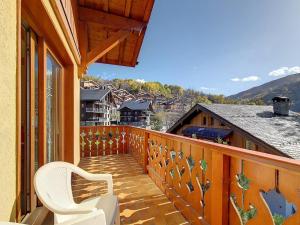 a balcony with a chair and a view of a house at Appartement Spacieux · Pied des Pistes · Balcon Terrasse · Parking Couvert · 6 Pers · Les Belleville - FR-1-344-355 in Saint-Martin-de-Belleville