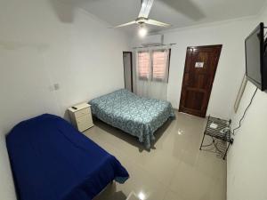 a bedroom with a blue bed and a tv at Antu Sol in Salta