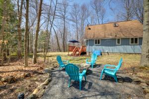 a group of blue chairs in front of a house at Walk to Beach Pocono Lake Cabin with Pool Access! in Pocono Lake