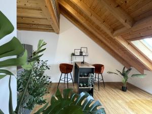 a living room with wooden ceilings and stools at Fewo-Forum in Kempten