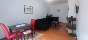 Una sala de estar con un sofá negro y una mesa. en APART Alojamentos Para Turismo e Negocios, en Braga