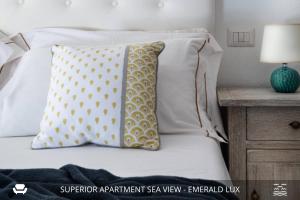 un letto con un cuscino e una lampada sul comodino di Homey Experience - Emerald Valley Sea View a Porto Cervo