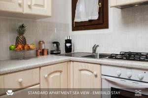 una cucina con lavandino e cesto di frutta di Homey Experience - Emerald Valley Sea View a Porto Cervo