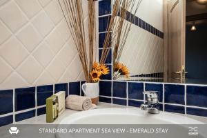 un bagno con pareti piastrellate blu e bianche e un lavandino di Homey Experience - Emerald Valley Sea View a Porto Cervo