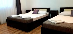 two twin beds in a room with wooden floors at Casa Eduard in Eforie Sud