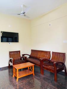 a living room with two leather couches and a coffee table at O'live Inn Wayanad Apart-Hotels in Vaduvanchal +11 photos