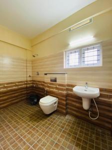 a bathroom with a toilet and a sink at O'live Inn Wayanad Apart-Hotels in Vaduvanchal +11 photos