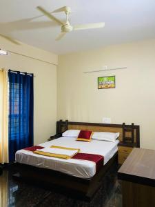 a bedroom with a bed with a ceiling fan at O'live Inn Wayanad Apart-Hotels in Vaduvanchal