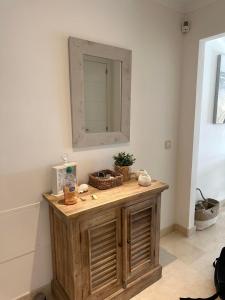 ein Badezimmer mit einem hölzernen Waschtisch und einem Spiegel in der Unterkunft Lovely apartment in Casares Beach in Casares