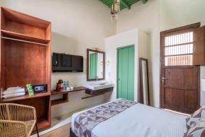 a bedroom with a bed and a sink and a mirror at Hotel Boutique Santa Elena in Mérida