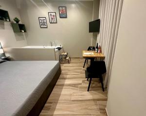 a bathroom with a bed and a sink and a desk at Qualora Room & Suite in Altamura