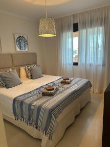 ein Schlafzimmer mit einem großen Bett mit zwei Geschirr darauf in der Unterkunft Lovely apartment in Casares Beach in Casares + 31 Fotos