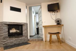 a living room with a fireplace and a stool at Jolie studio in Argenteuil