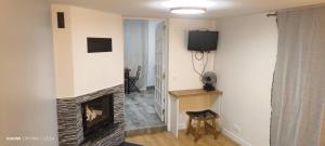 a living room with a fireplace and a television at Jolie studio in Argenteuil +1 photo