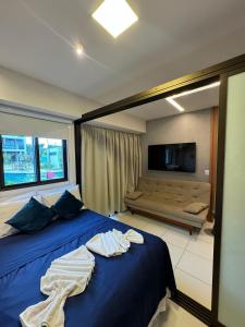 a bedroom with a blue bed with towels on it at Makia Beach Experience By All in Porto De Galinhas +44 photos